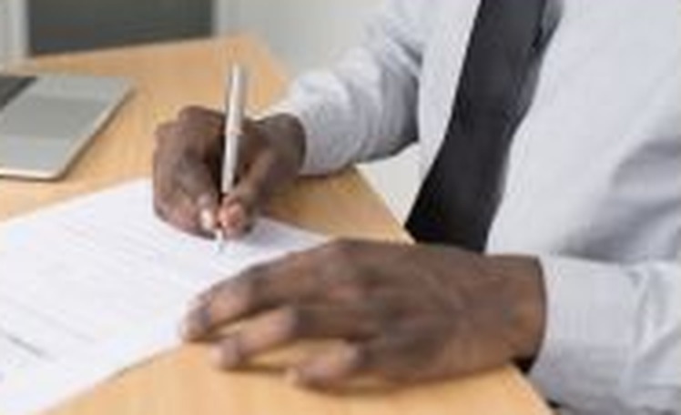 Borrower signing loan documents at a desk