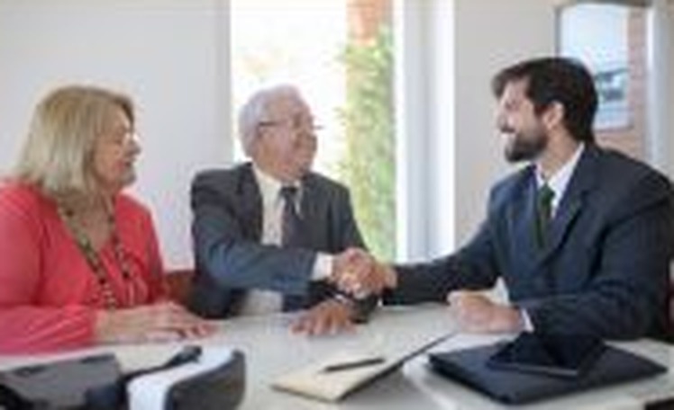 Team shaking hands with clients in a meeting room